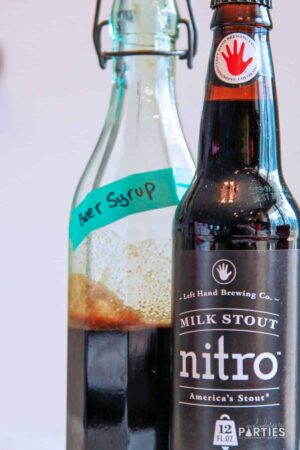 A bottle of beer syrup next to a bottle of Left Hand Brewing Milk Stout Nitro.