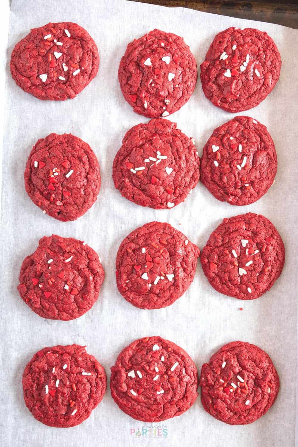 Red velvet cake mix cookies on a pan after baking.