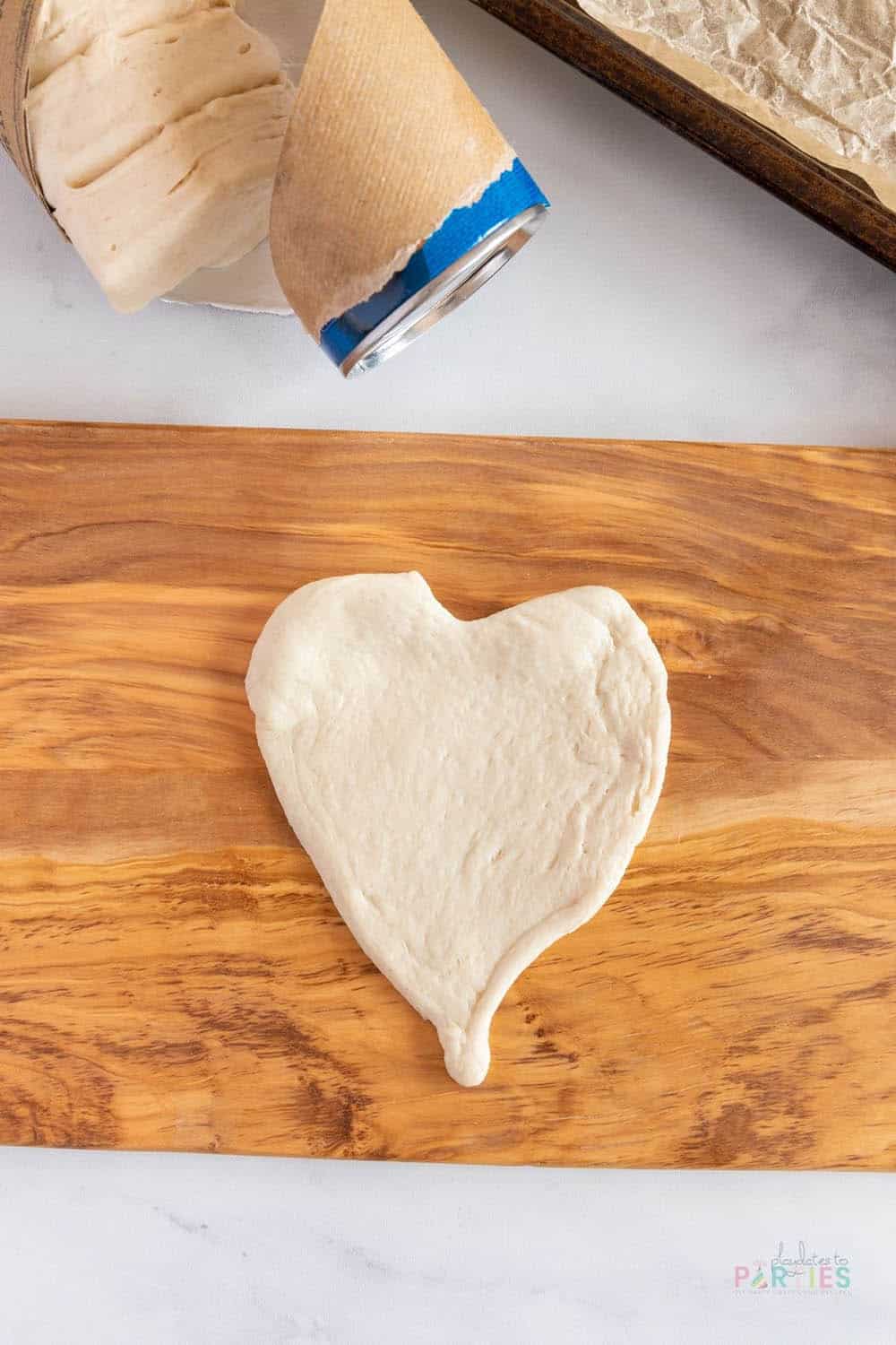 Mini heart shaped pizza crust on a cutting board.