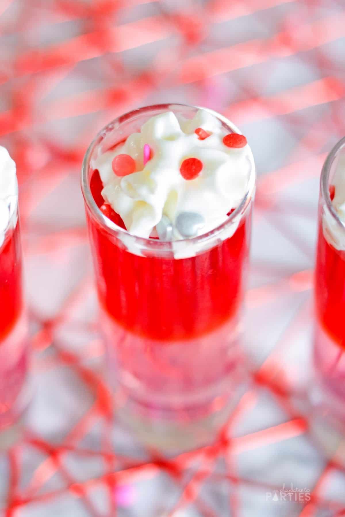 Close up of whipped cream and sprinkles on a jello shot.