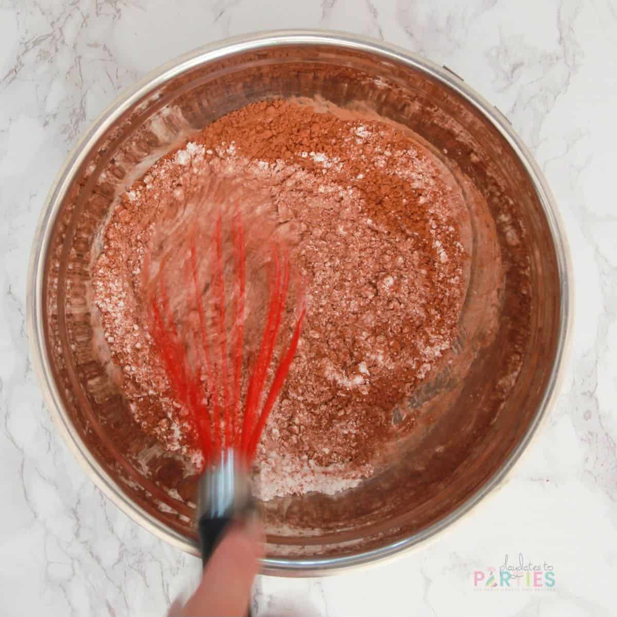Whisking dry ingredients for chocolate whipped cream frosting.