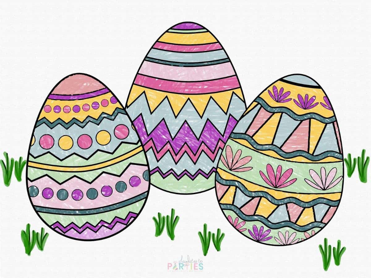 A finished coloring page with three eggs in the grass.