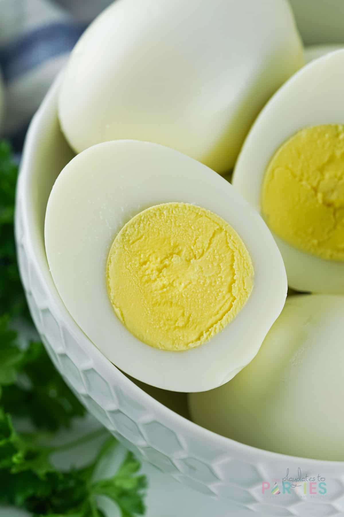 Close up of a hard boiled egg cut in half that has no green around the yolk.