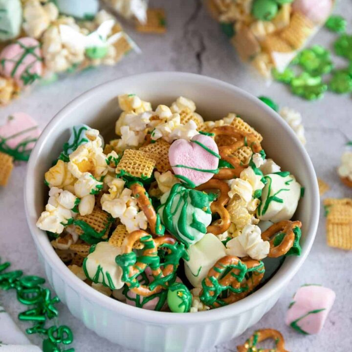 A bowl of St. Patrick's Day snack mix on a concrete surface.