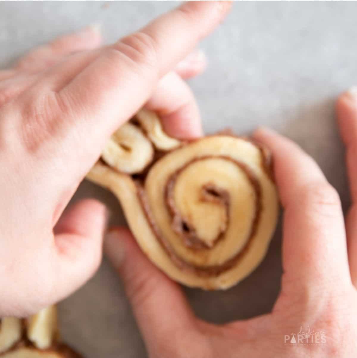 Shaping a cinnamon roll into a bunny.