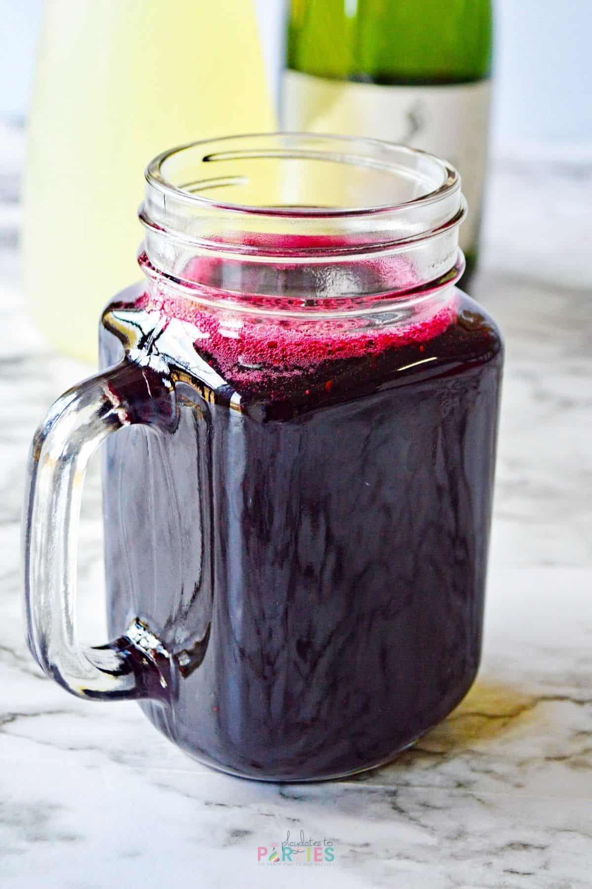 Blueberry simple syrup in a mason jar mug.