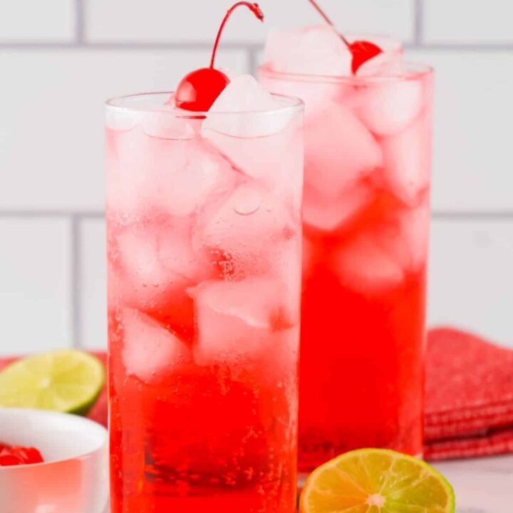 Two Shirley Temple mocktails on a marble counter.