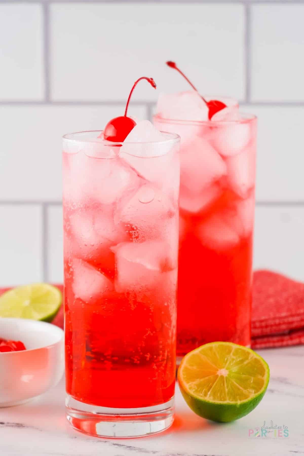Two Shirley Temple mocktails on a marble counter.