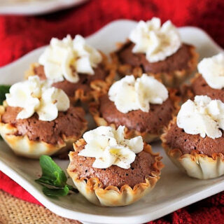Mini chocolate chess pies on a white plate.