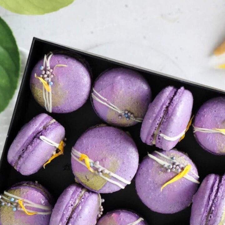 A box filled with purple early grey macarons.