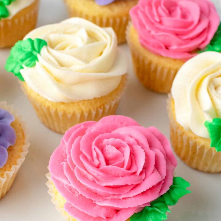 Cupcakes on a white surface decorated to look like flowers.