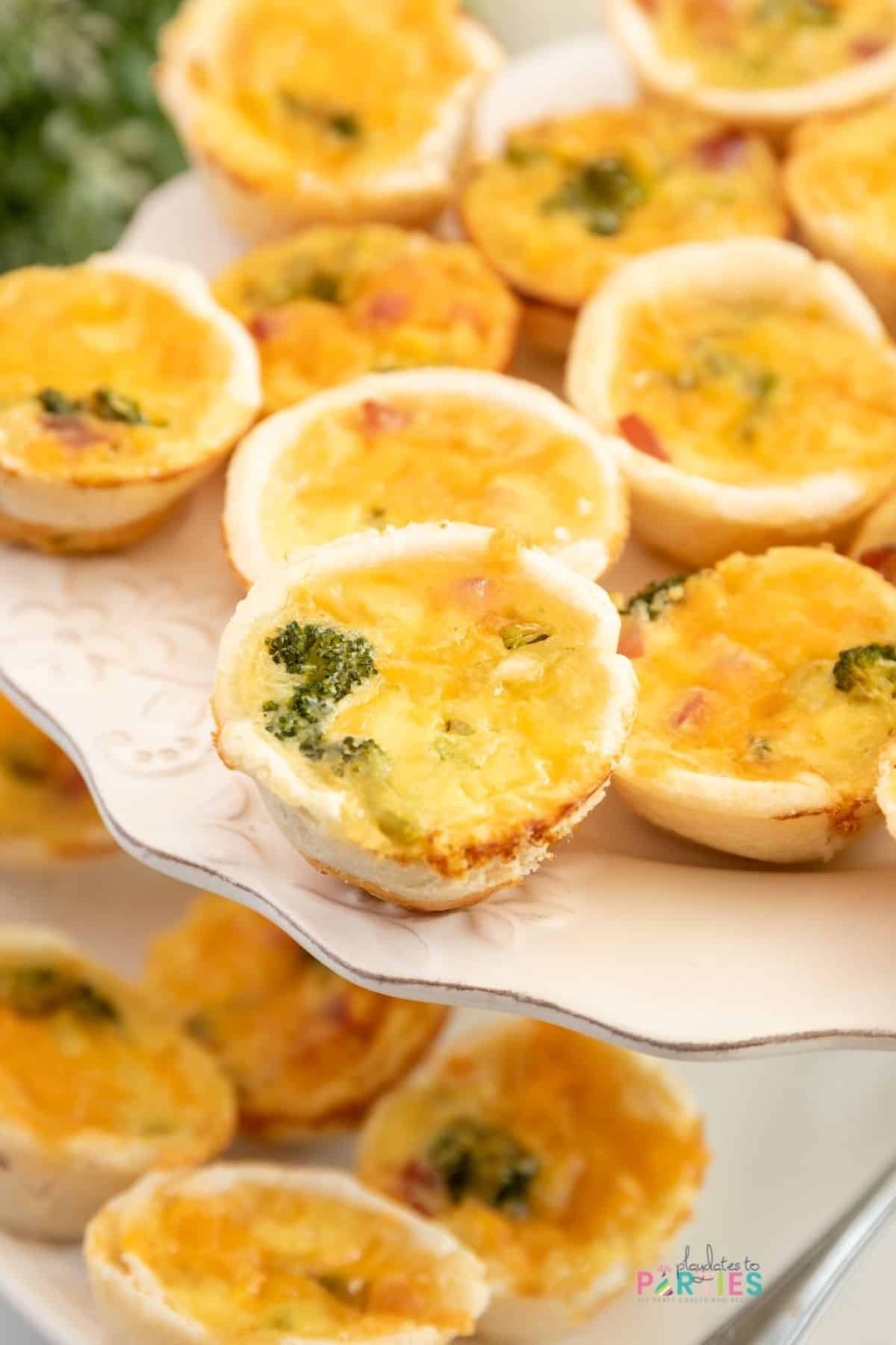Mini quiche on a tiered white party tray.