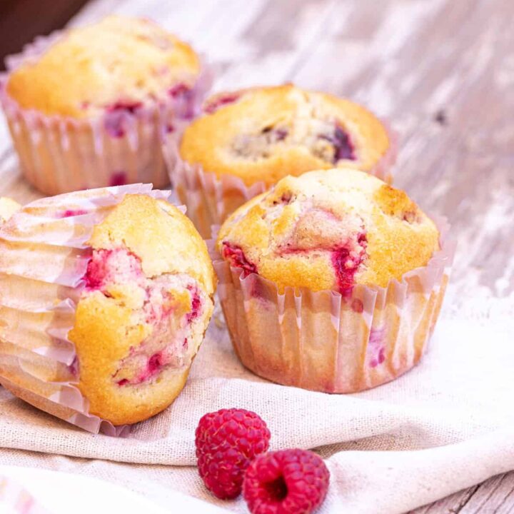 Lemon raspberry muffins on a tea towel.