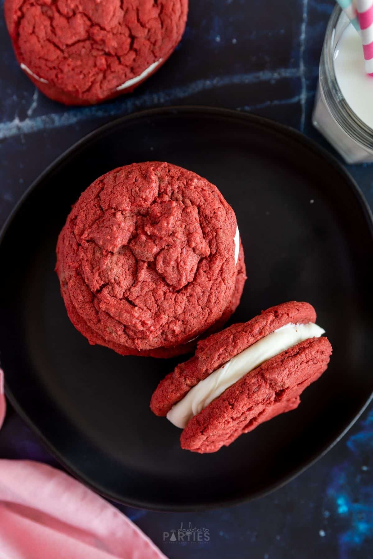 Overhead view of red cookies on a black plate.
