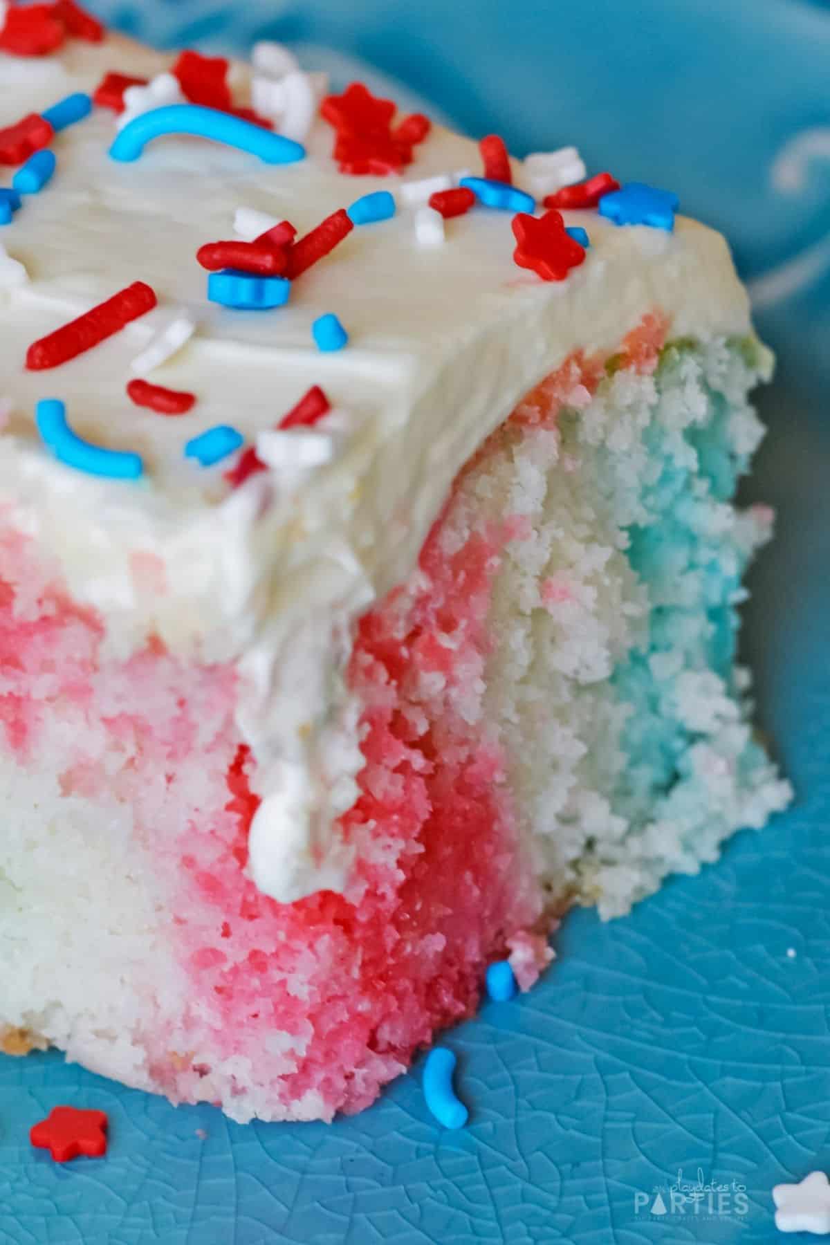 Close up of a July 4th poke cake with red and blue stripes.