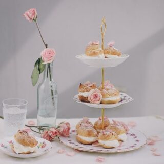 A tea party tray filled with cream puff desserts.