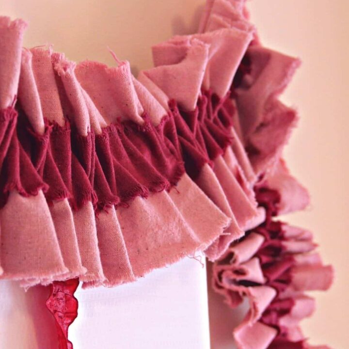 A layered ruffled fabric garland hanging on a wall.