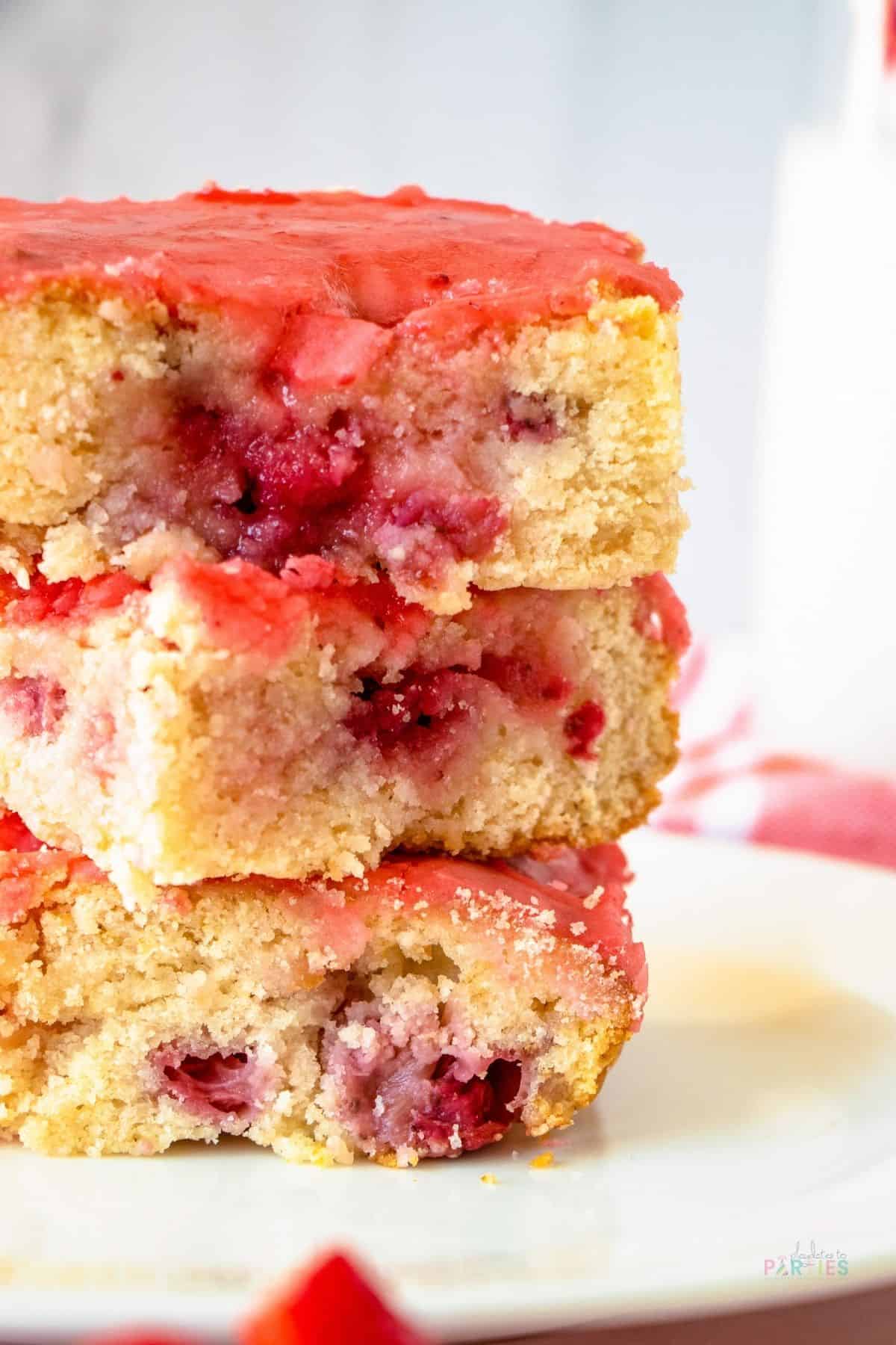 Close up of lemon strawberry blondies stacked on a plate.