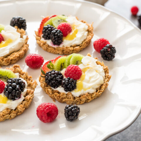 A miniature tart made with a granola crust, filled with cream and fresh fruit.