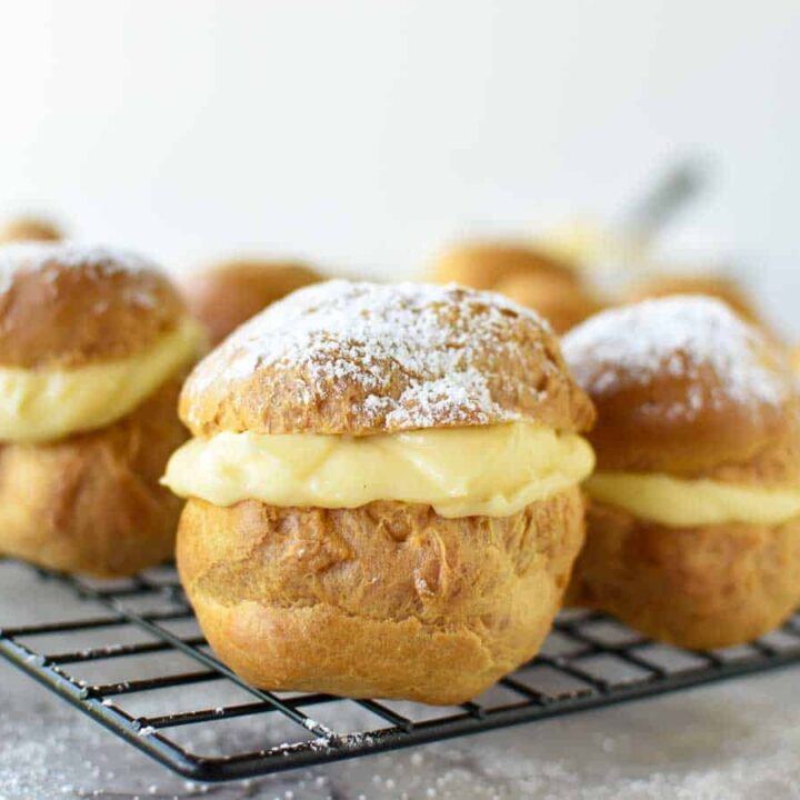 Close up of cream puffs on a cooling rack.