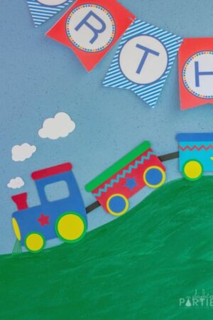 Close up of 2 dimensional paper train on a blue backdrop that looks like it's rolling down a hill.