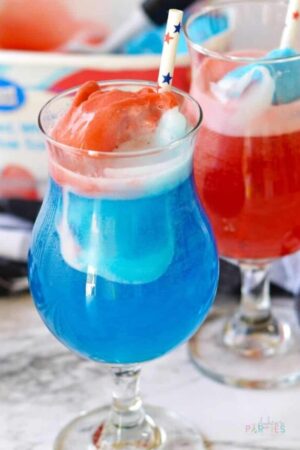 Close up of a hurricane glass with red white and blue patriotic punch for July 4th.