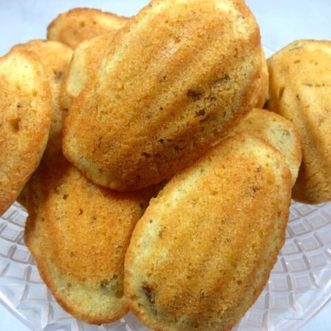 Madeline cookies on a glass cake stand.