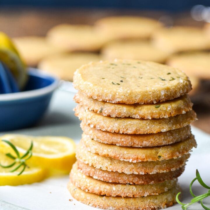 A stack of lemon rosemary butter cookies on a piece of parchment paper.