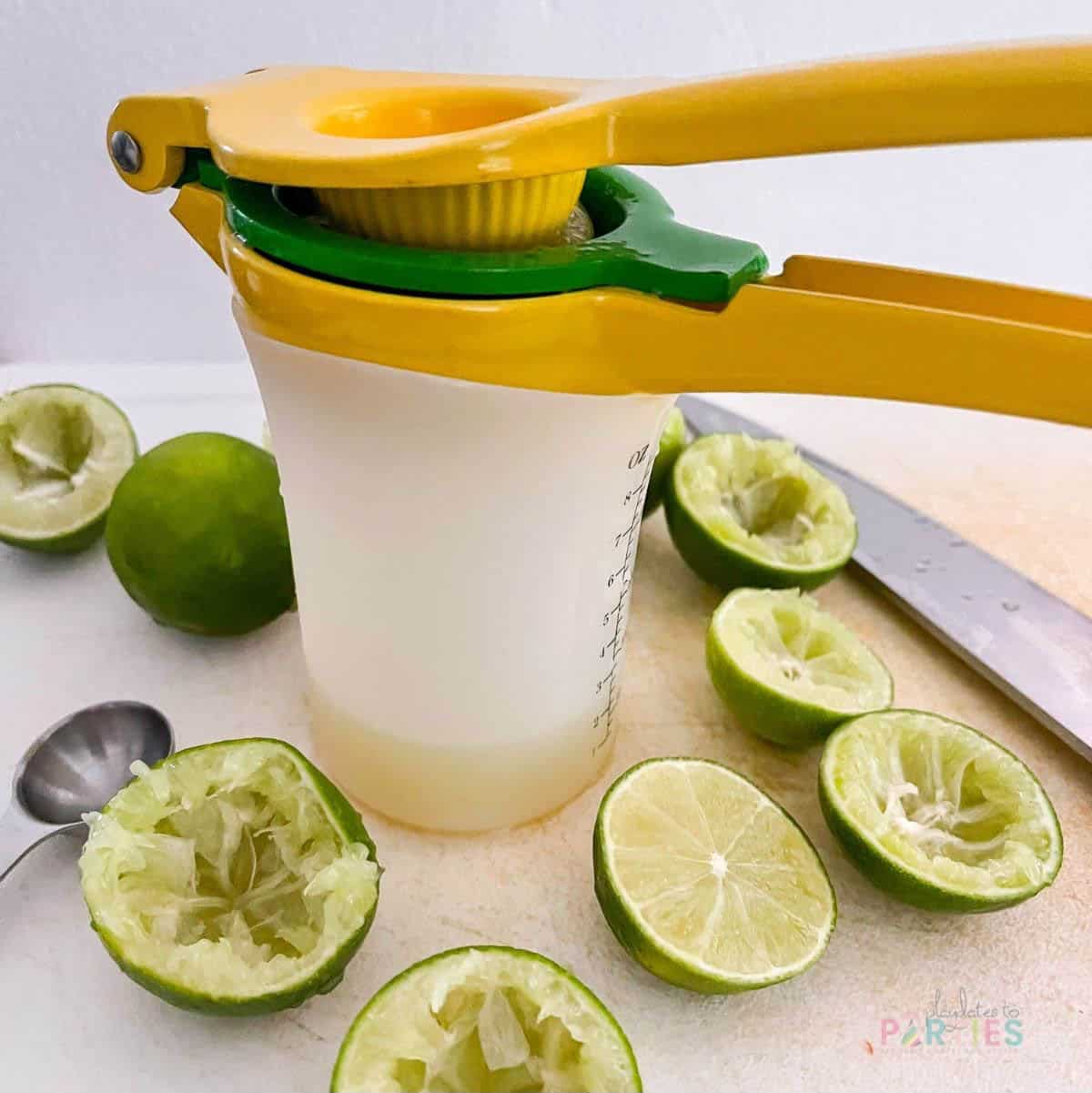 Bulk juicing limes into a measuring cup for party cocktails.