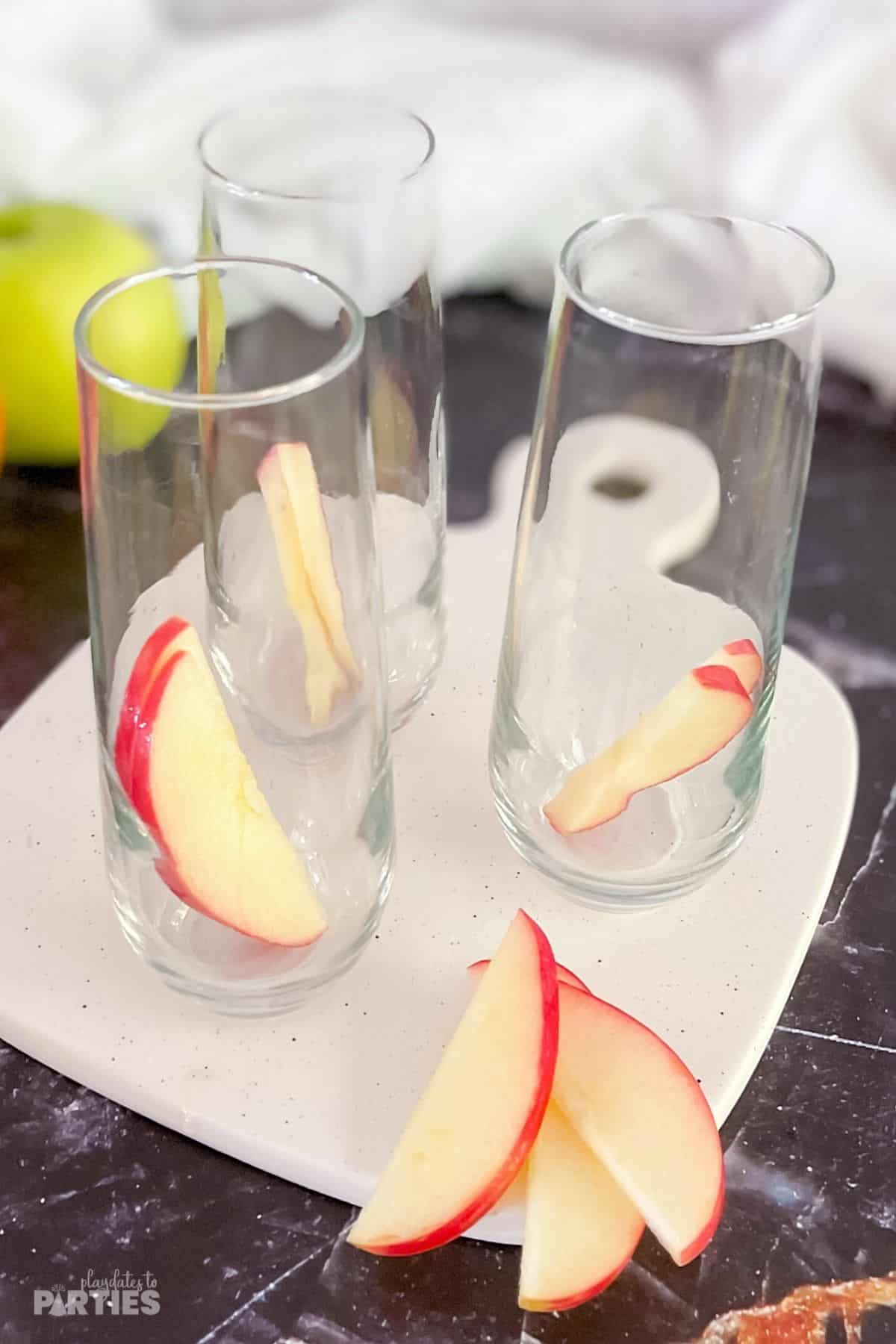 Apple slices in champagne flutes.