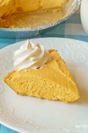 A slice of creamy pumpkin cheesecake on a white plate.