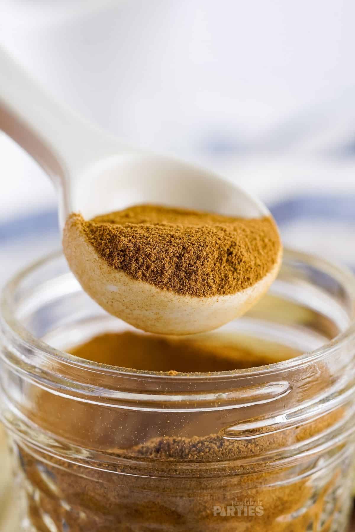 A teaspoon is used to measure out homemade apple pie spice mix.