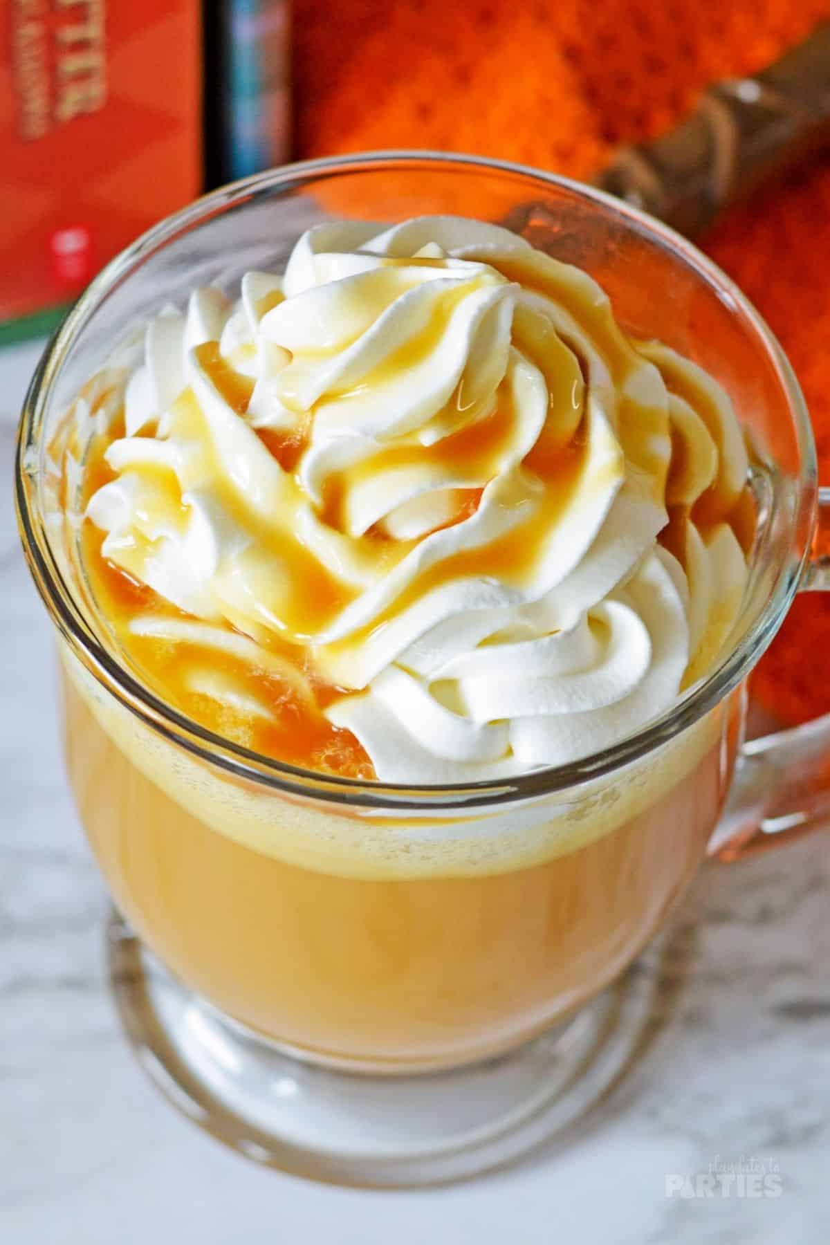 Looking down at a mug filled with a cream soda, topped with whipped cream and butterscotch.