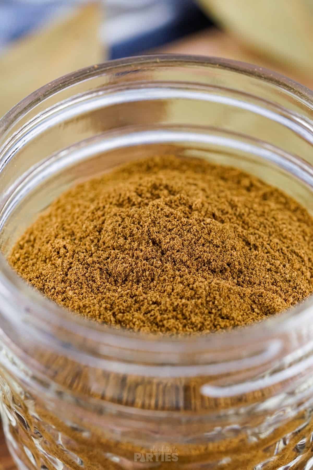 Close up of homemade apple pie spice in a glass mason jar.