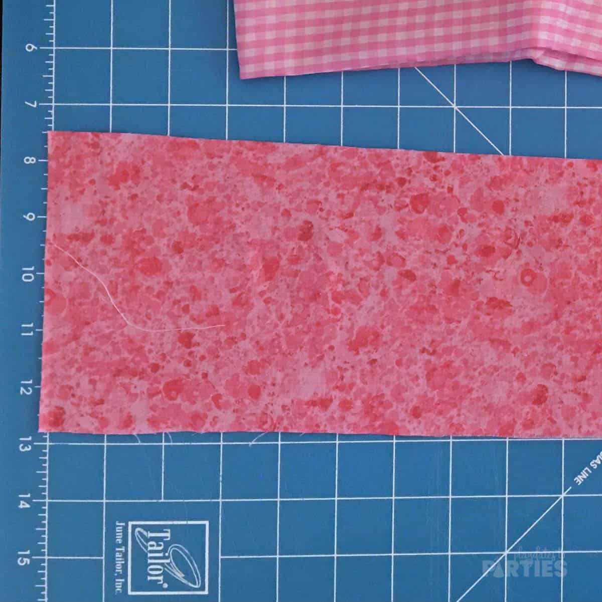 A strip of fabric on a blue quilting mat.
