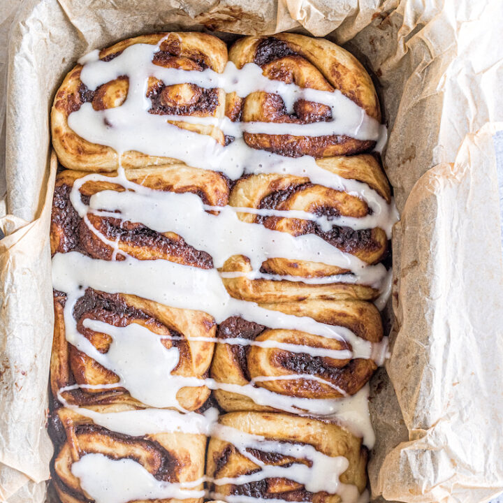 Cinnamon rolls fresh from the oven are drizzled with plenty of glaze.