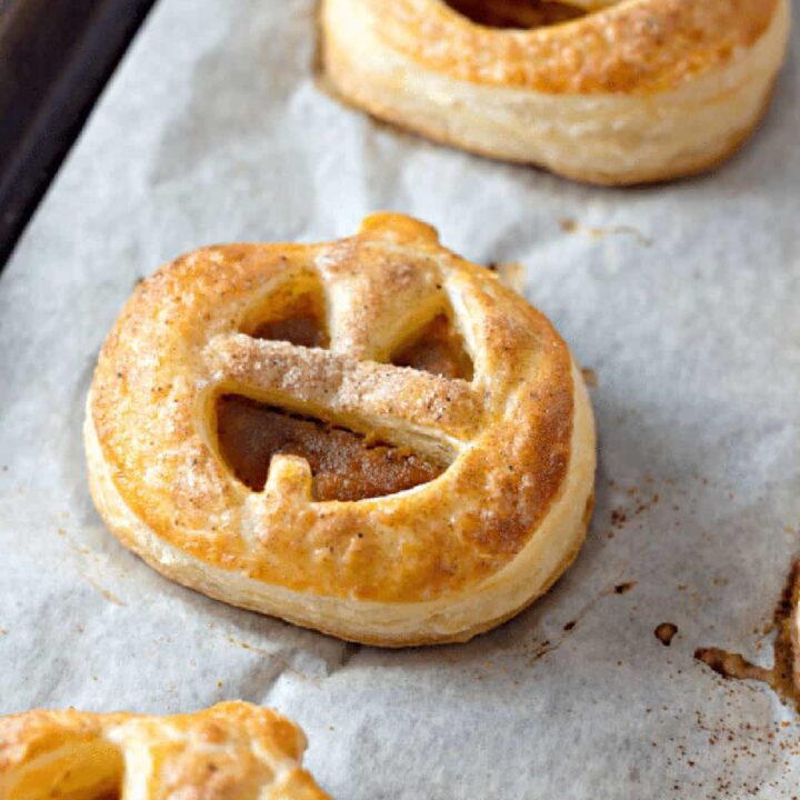 Jack o lantern hand pies are filled with pumpkin filling and baked until golden.