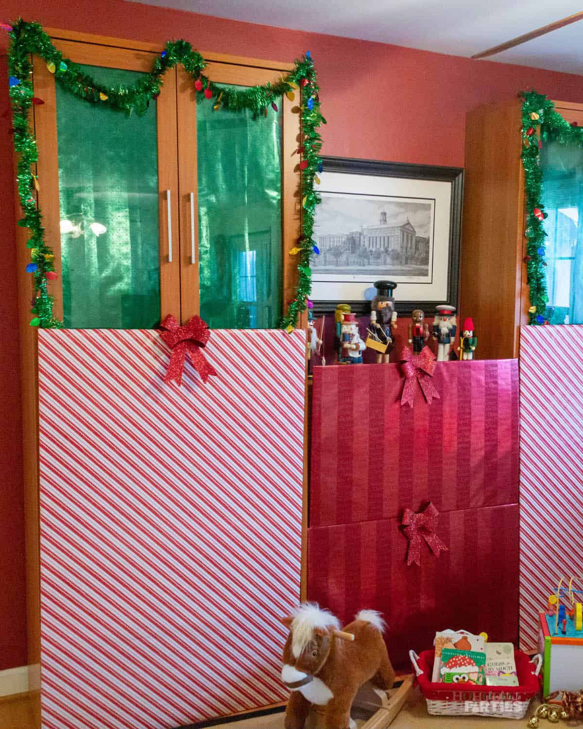 Large cardboard pieces decorated to look like giant Christmas gifts for a party.