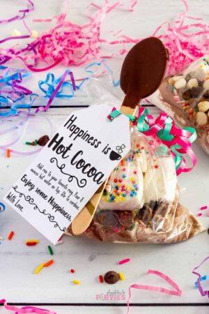 A cellophane gift bag filled with hot chocolate with a printable tag attached.