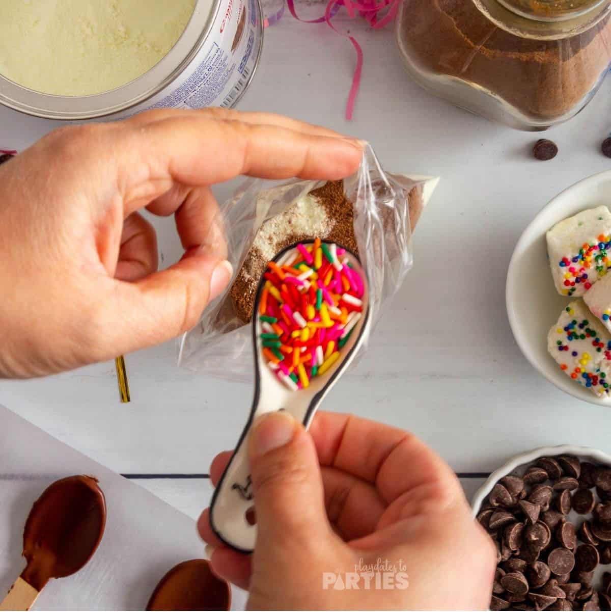 Pouring rainbow sprinkles into a hot chocolate favor bag.