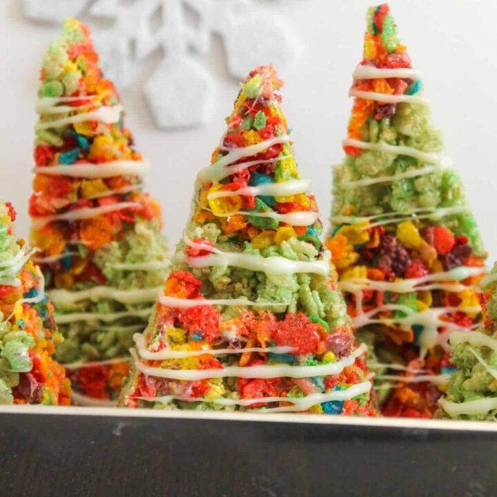Rice Cereal Christmas Trees with colorful cereal and a white chocolate drizzle.