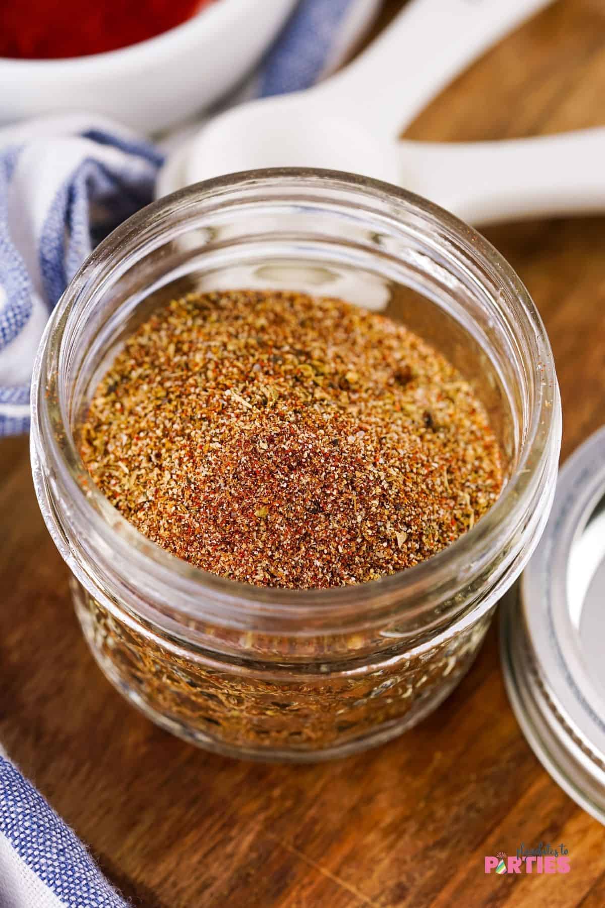 A glass jar filled with taco seasoning mix.