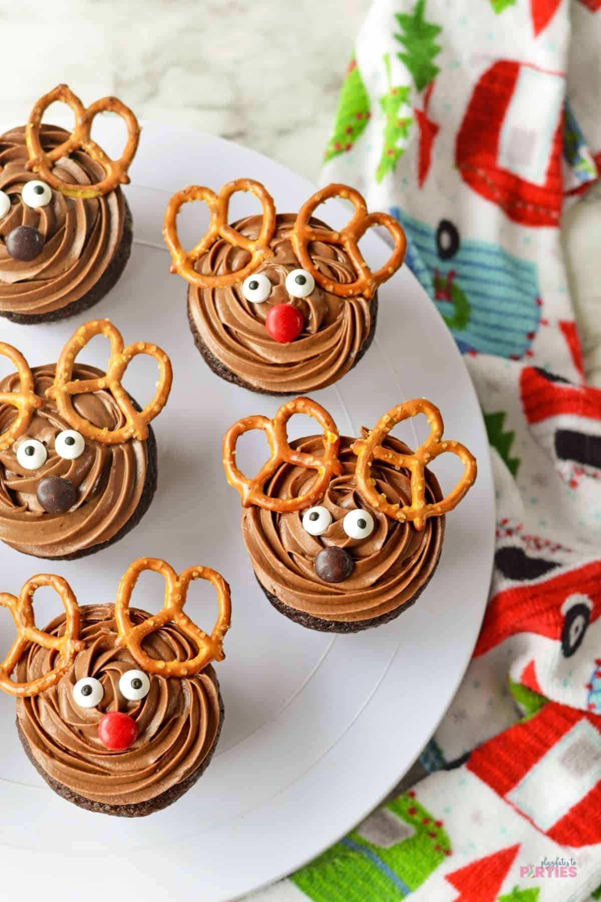 Christmas cupcakes on a dessert stand decorated to look like reindeer.