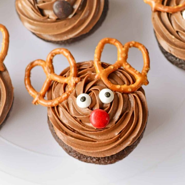 Reindeer cupcakes on a white cake stand.