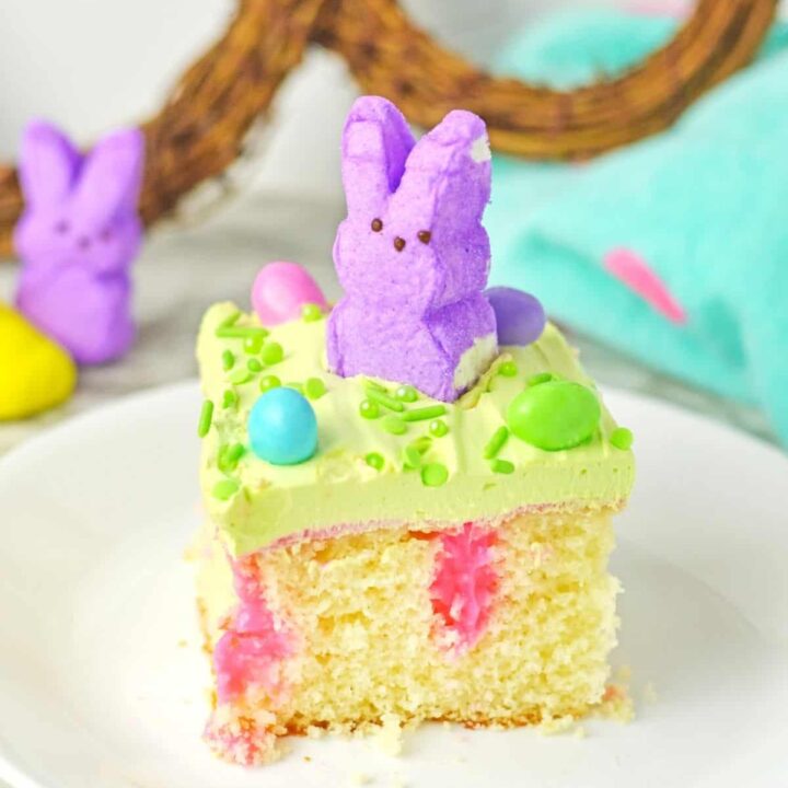 A slice of Easter poke cake with peeps and M&Ms.