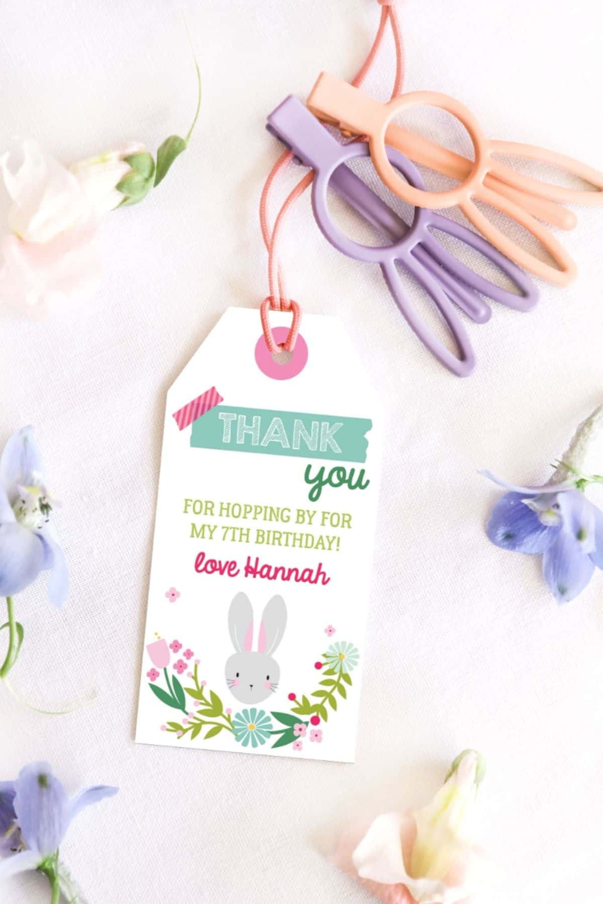 A spring themed favor tag with a bunny face on it.