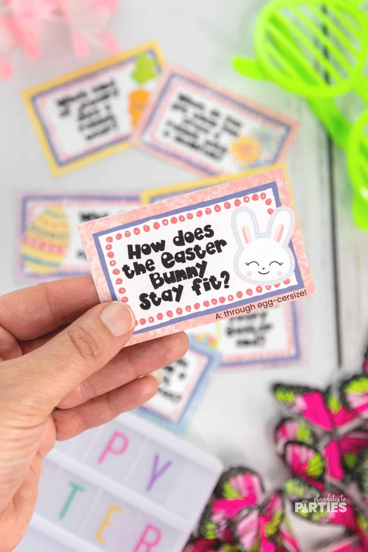 A woman's hand holding an Easter joke card.