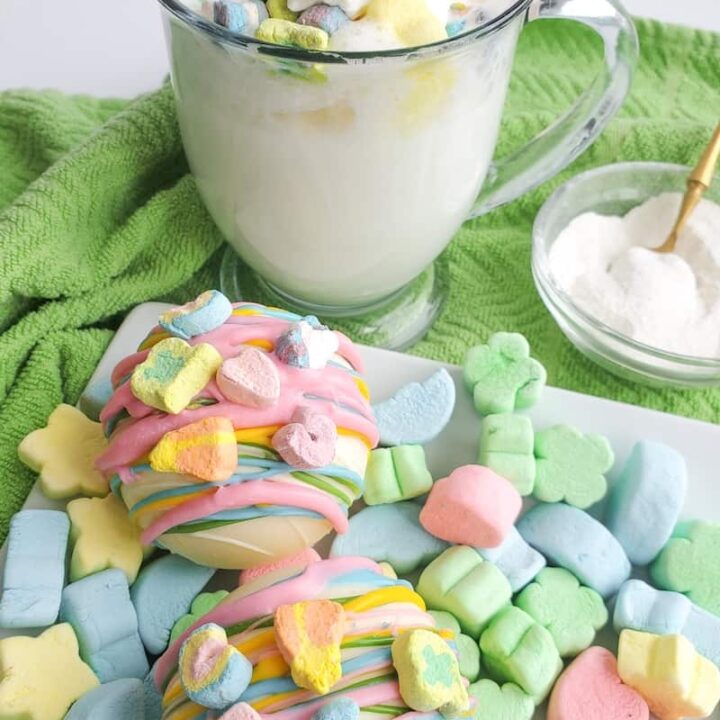 White chocolate hot cocoa bombs made with colorful Lucky charms marshmallows for St. Patrick's Day.