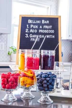 A Bellini bar with a felt letter board and three fruit purees.