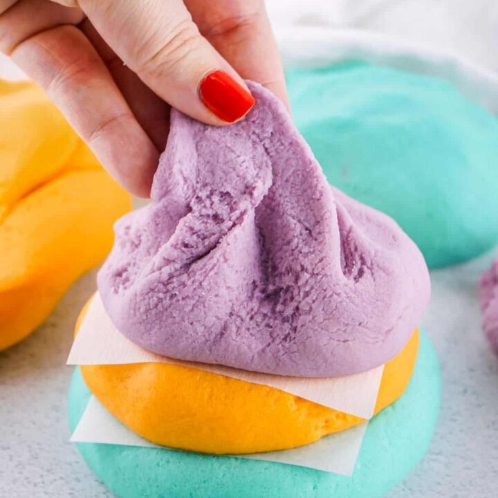 A woman's hand pulling at a finished recipe for homemade playdough.